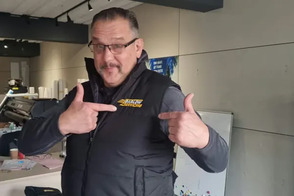 John Barlow pointing at the J Barlow Servicing logo embroidered in yellow on his black bodywarmer